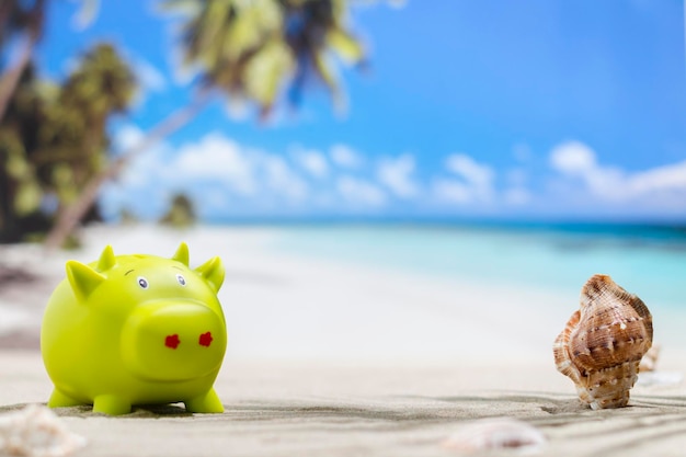 Piggy bank on sunny beach Savings for vacation concept