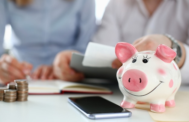 Piggy bank on table aganist home background