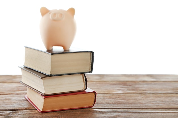 Foto piggy bank in cima a libri isolati su bianco