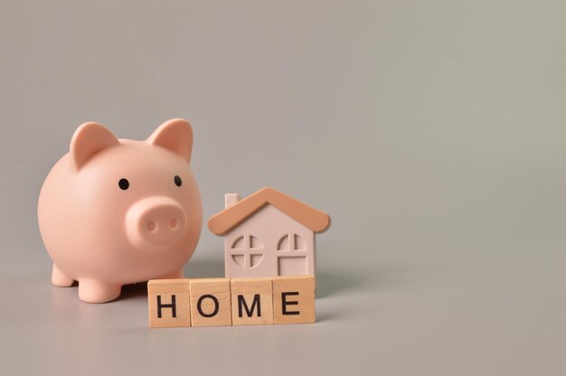 Piggy bank toy house and wooden blocks with text HOME