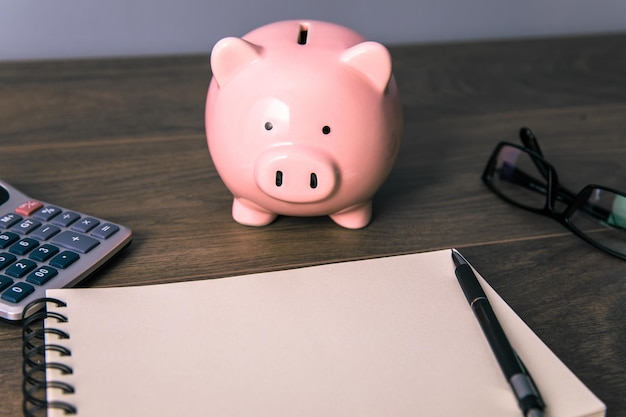 Piggy bank with calculator and notepad