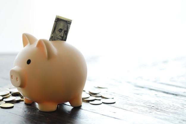 Piggy bank with coin on old wooden table