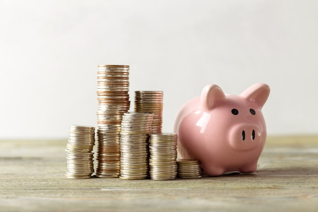 Piggy bank with coin on old wooden table