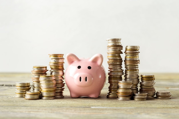 Piggy bank with coin on old wooden table