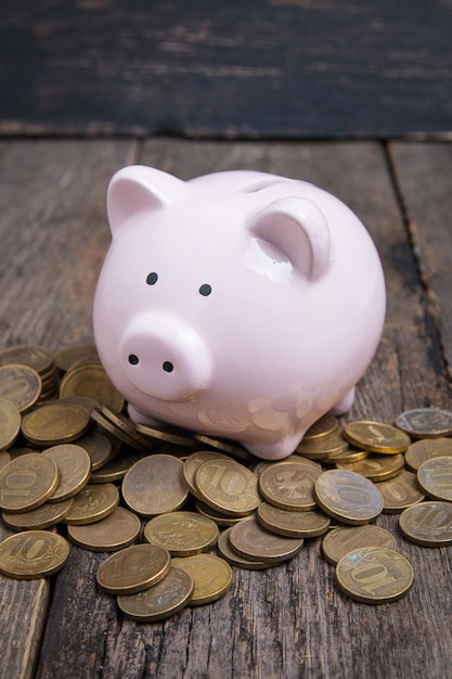 Piggy bank with coin on wooden table