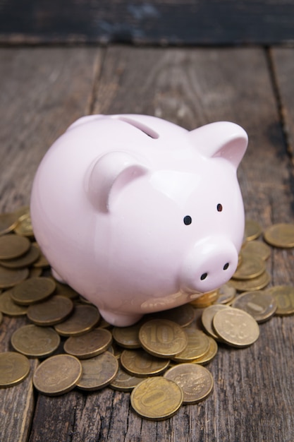 Piggy bank with coin on wooden table