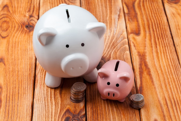 piggy bank with coin on wooden table