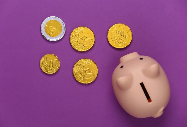 Photo piggy bank with coins on purple