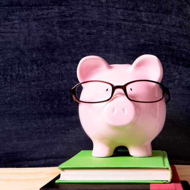 Photo piggy bank with glasses and blackboard