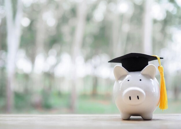 Piggy bank with graduation hat The concept of saving money for education student loan scholarship tuition fees in future