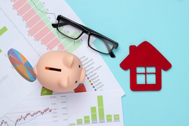 グラフやチャート、青の家の図と貯金箱。住宅費分析