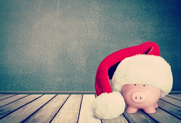 Foto salvadanaio con cappello di babbo natale sullo sfondo