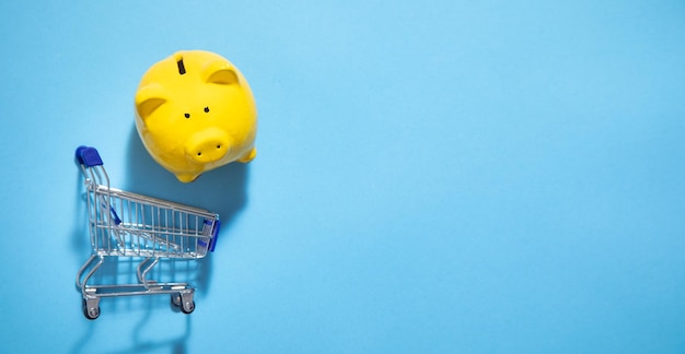 Piggy bank with a shopping cart on the blue background