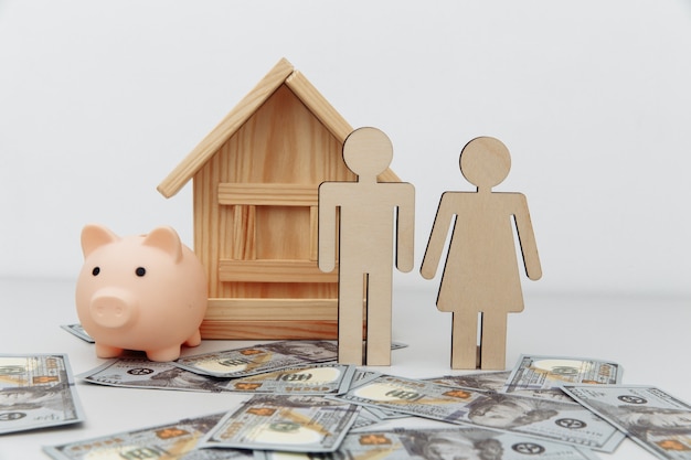 Piggy bank and wooden family with house