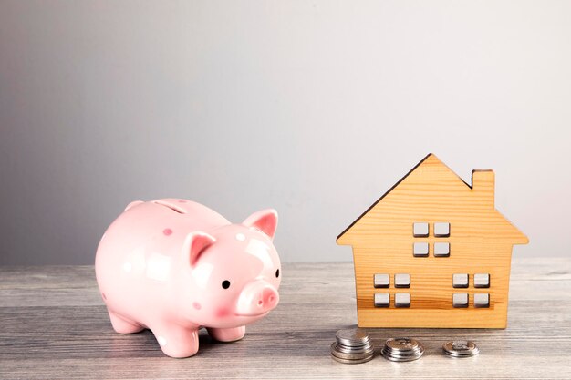 piggy bank and wooden house model on the table