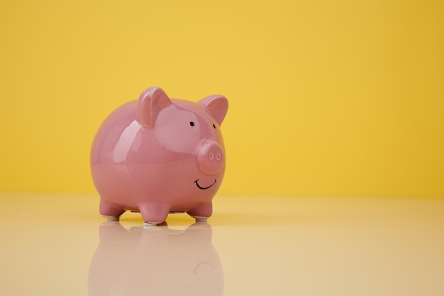 Piggy bank on yellow background investmenst and savings concept