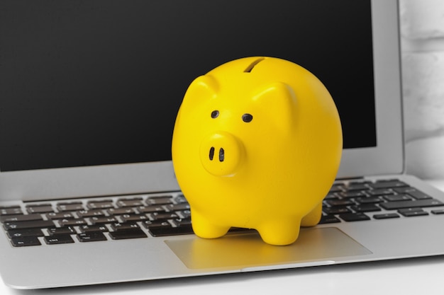 Piggybank on laptop keyboard in money saving concept