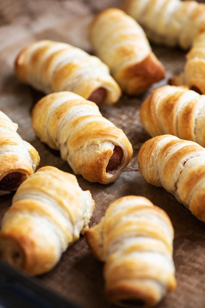 Photo pigs in a blanket puff pastry baking with sausages