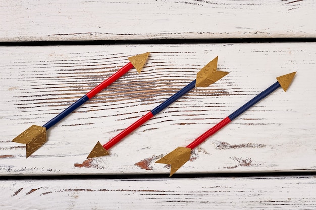 Foto pijlen op houten achtergrond. gouden pijlpunten. een decoratief boogschietwapen maken.