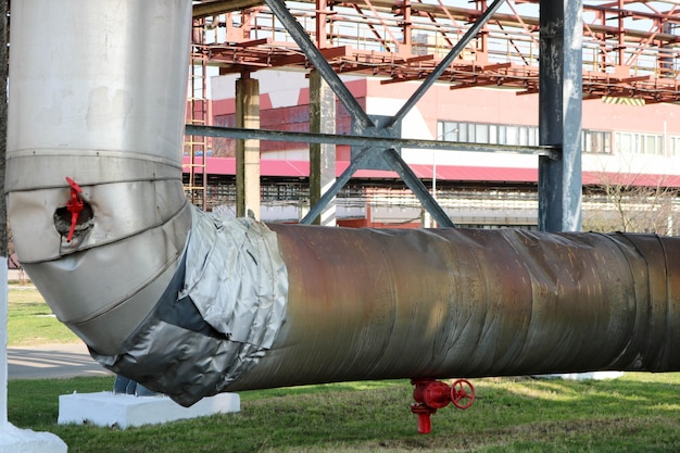 Pijpleiding estocad grote stoompijp in isolatie gemaakt van glasvezel met rode ventrals fittingen kleppen drainage met blauwe balken in olieraffinaderij petrochemische fabriek