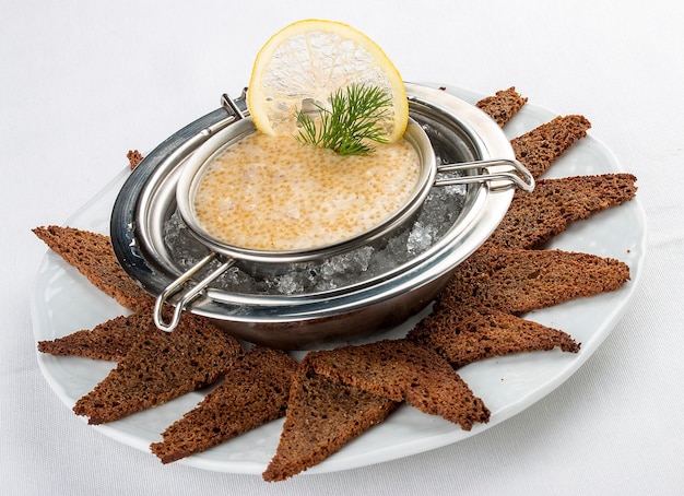 Photo pike caviar on ice with toast on white background