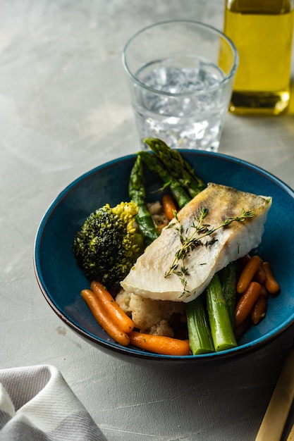 Pike perch fillet with asparagus, broccoli and carrots. Fried fish with stewed greens