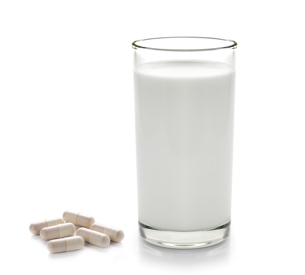 Pil en glas melk op witte ruimte wordt geïsoleerd die