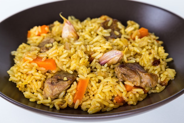 Pilaf con agnello, carote, cipolle, aglio, pepe e crespino. un piatto tradizionale della cucina asiatica.