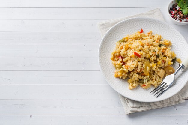 Pilaf with vegetables and chicken in a gray plate  Copy space