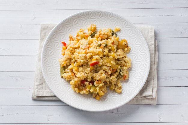 Pilaf with vegetables and chicken in a gray plate on a light .