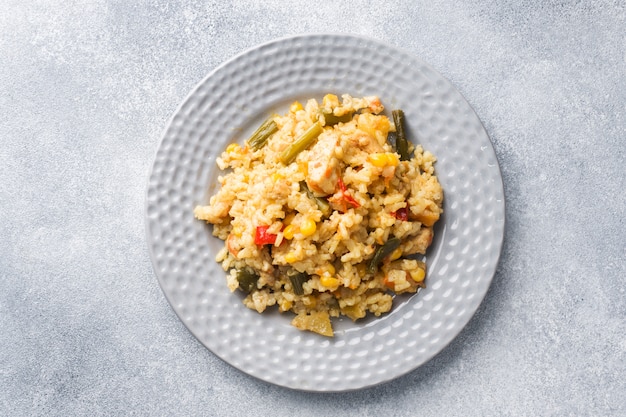 灰色のプレートに野菜と鶏肉のピラフ