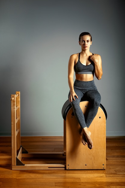 Pilates, fitness, sport, training and people concept - woman doing exercises on a small barrel. Correction of impellent apparatus, correct posture.