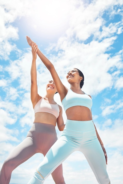 Pilates personal trainer and woman client learning wellness support and workout exercise accountability or trust on blue sky clouds Stretching people mentor or coach training with sun lens flare