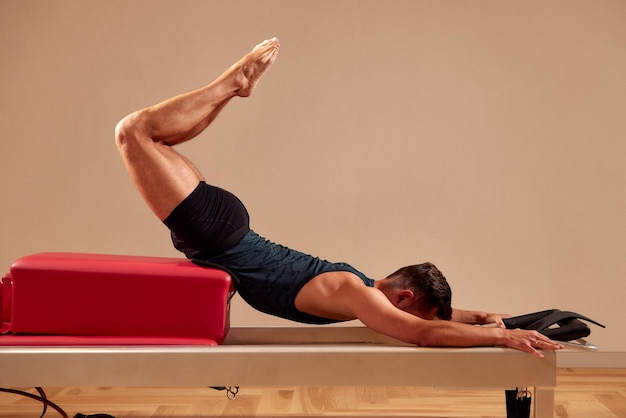 Pilates reformer workout exercises man at gym indoor