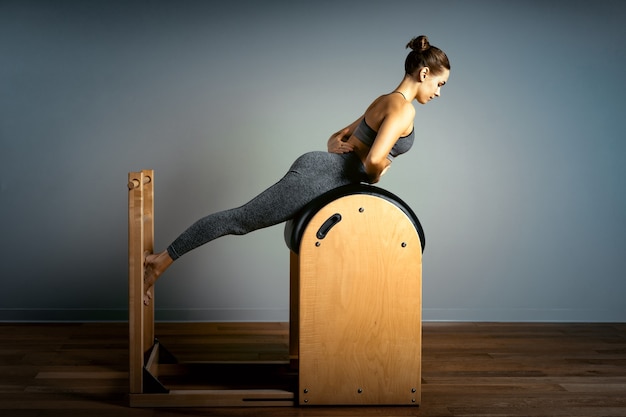 Premium Photo  Young girl exercises on a bed of pilates reformers