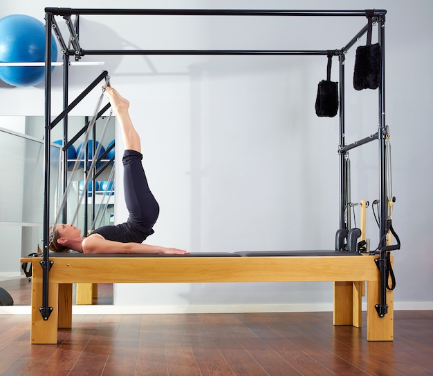 Pilates vrouw in hervormer toren oefenen op gymnasium