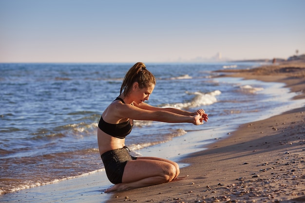 Pilates yoga workout oefening buiten op het strand