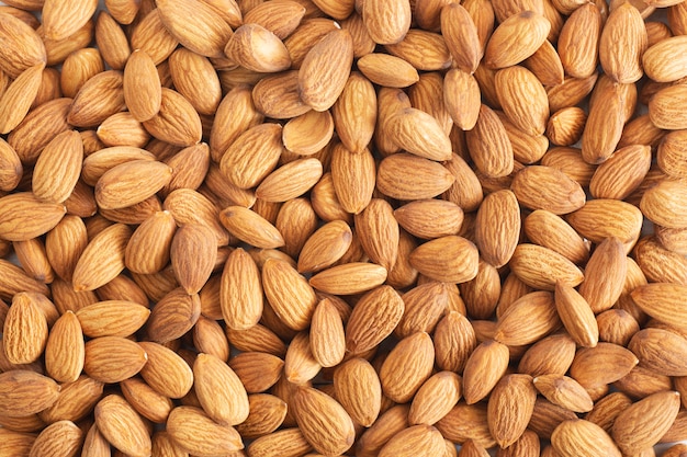 Pile of almond nuts on wood table,Top view.