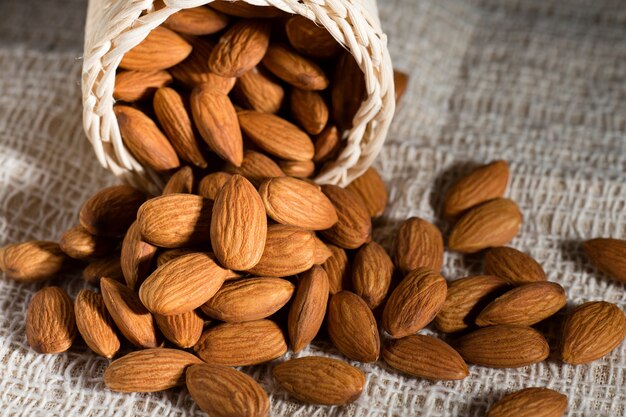 pile of almond nuts on wooden table.