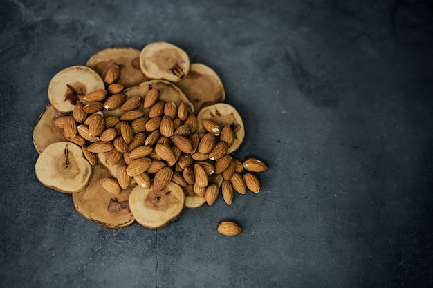 A pile of almonds on a dark background nuts are a source of vitamins useful for health