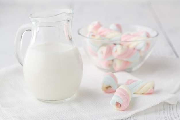 Pile of american twisted marshmallow on table with glass of milk
