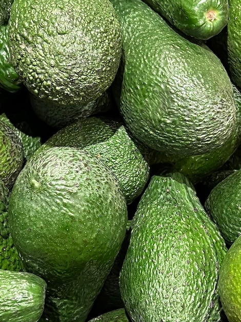 A pile of avocados are stacked up.