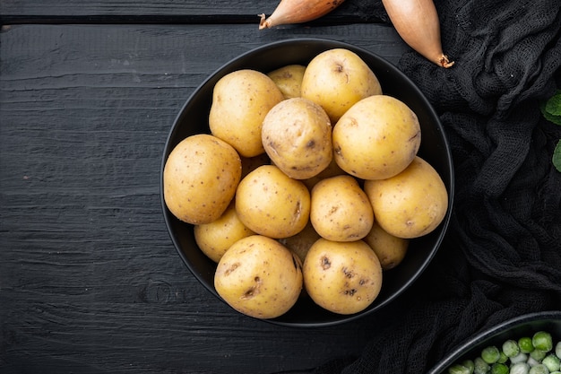 Pile of baby potatoes, flat lay, on black wooden table