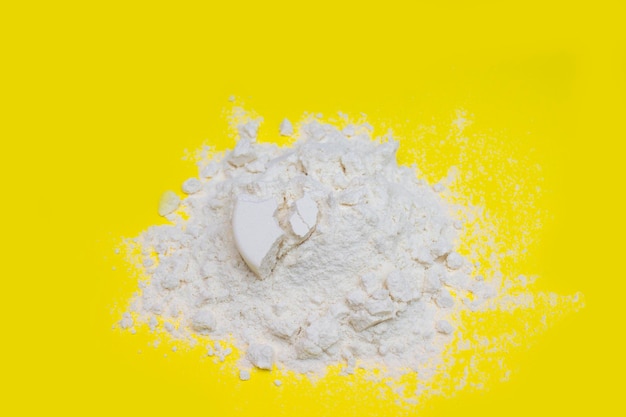 Pile of banana protein powder isolated on yellow background