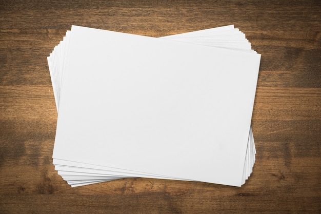 Photo pile of blank paper on wooden table