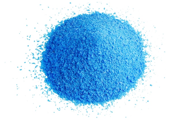 Pile of blue copper sulfate granules closeup isolated on white background