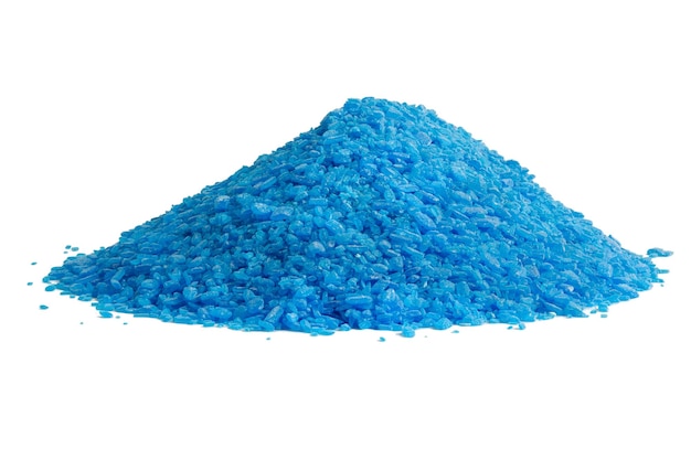 Pile of blue copper sulfate granules closeup isolated on white background