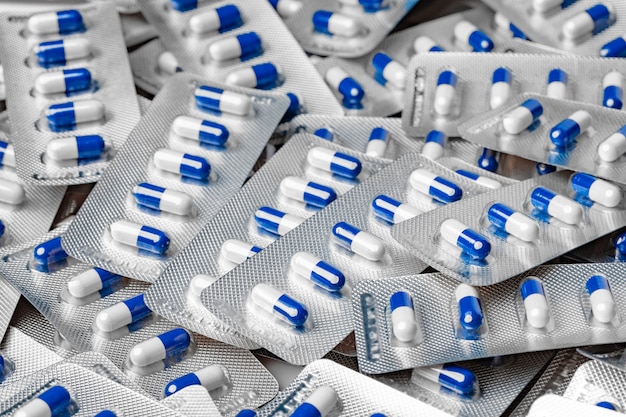 Pile of Blue and white capsule pills in blister packs