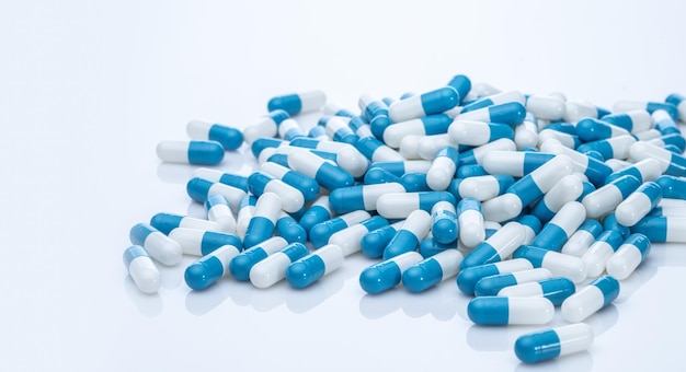 Pile of blue and white capsule pills Pharmacy product Prescription drug Healthcare and medicine