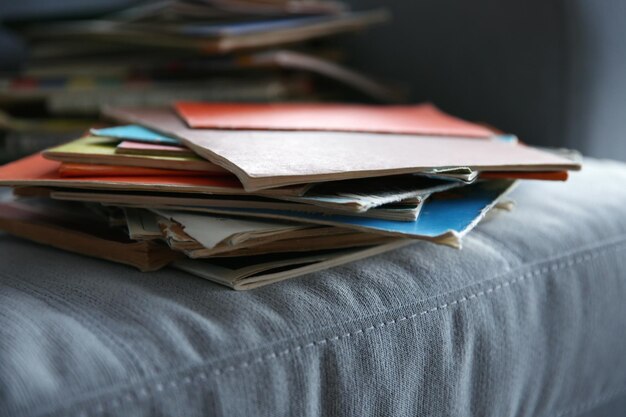 Pile of books on grey sofa close up